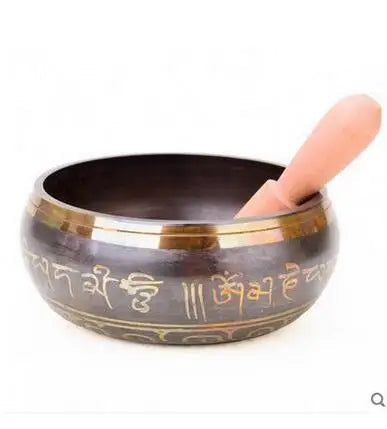 Tibetan singing bowl with gold inscriptions on a white background