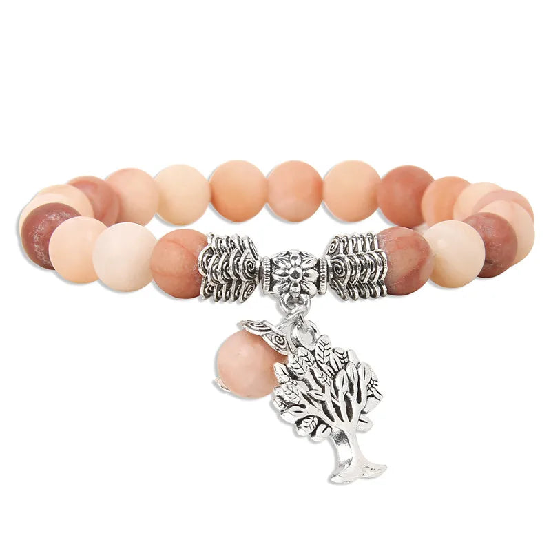 Bracelet with multicolored beads and silver tree charm on a white background