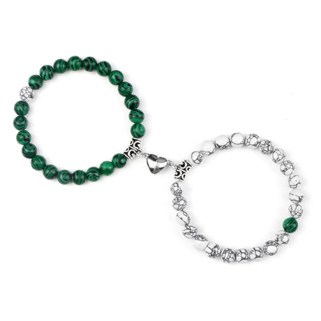 Two bracelets, one green beaded and one silver with white stones, on a white background.