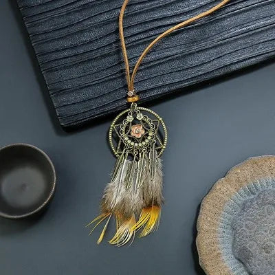 Decorative dreamcatcher with feathers on a dark surface