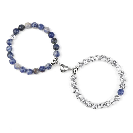 Two bracelets, one blue beaded and one silver chain, on a white background
