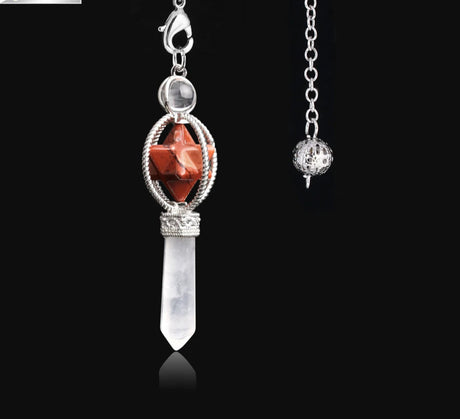 Jewelry pendant with red stone and clear crystal on a black background