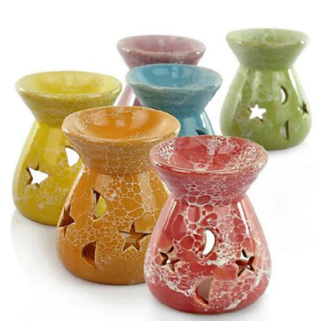 Set of colorful ceramic oil burners with star designs on a white background