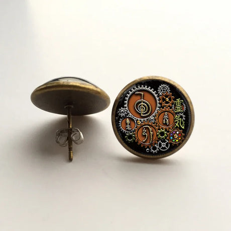 Steampunk-style earrings with intricate designs on a white background