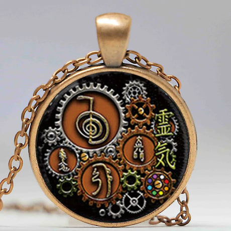 Pendant with intricate design featuring gears and symbols on a black background, with a gold chain.