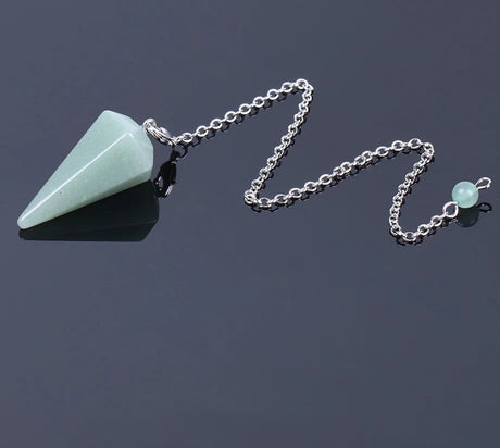 Green stone pendant on a silver chain against a dark background
