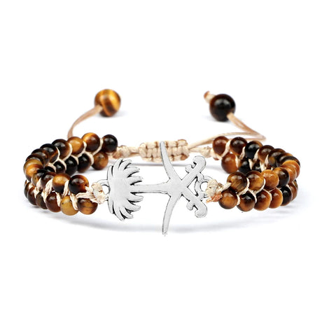 Bracelet with tiger eye beads and silver charm on a white background