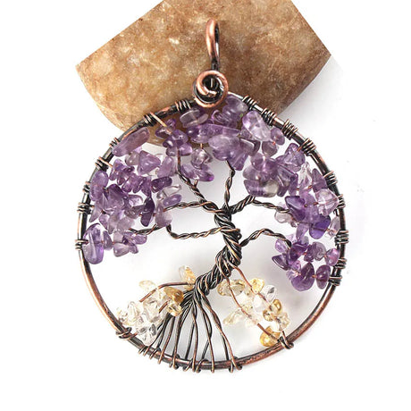 Tree of Life pendant with purple and clear gemstones on a white background