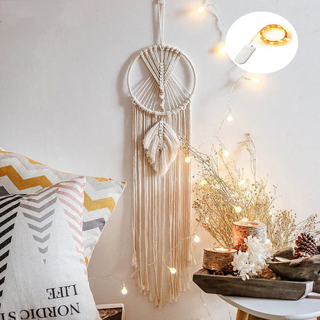 Dreamcatcher hanging on a wall with string lights and decorative items.
