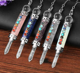 Five crystal necklaces with colorful stones on a wooden surface