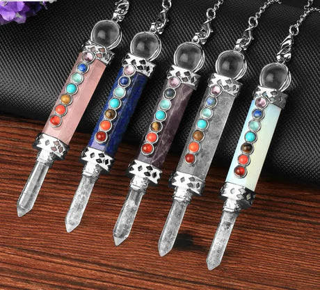 Five crystal necklaces with colorful stones on a wooden surface