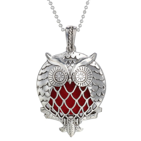 Silver owl pendant with red center on a white background