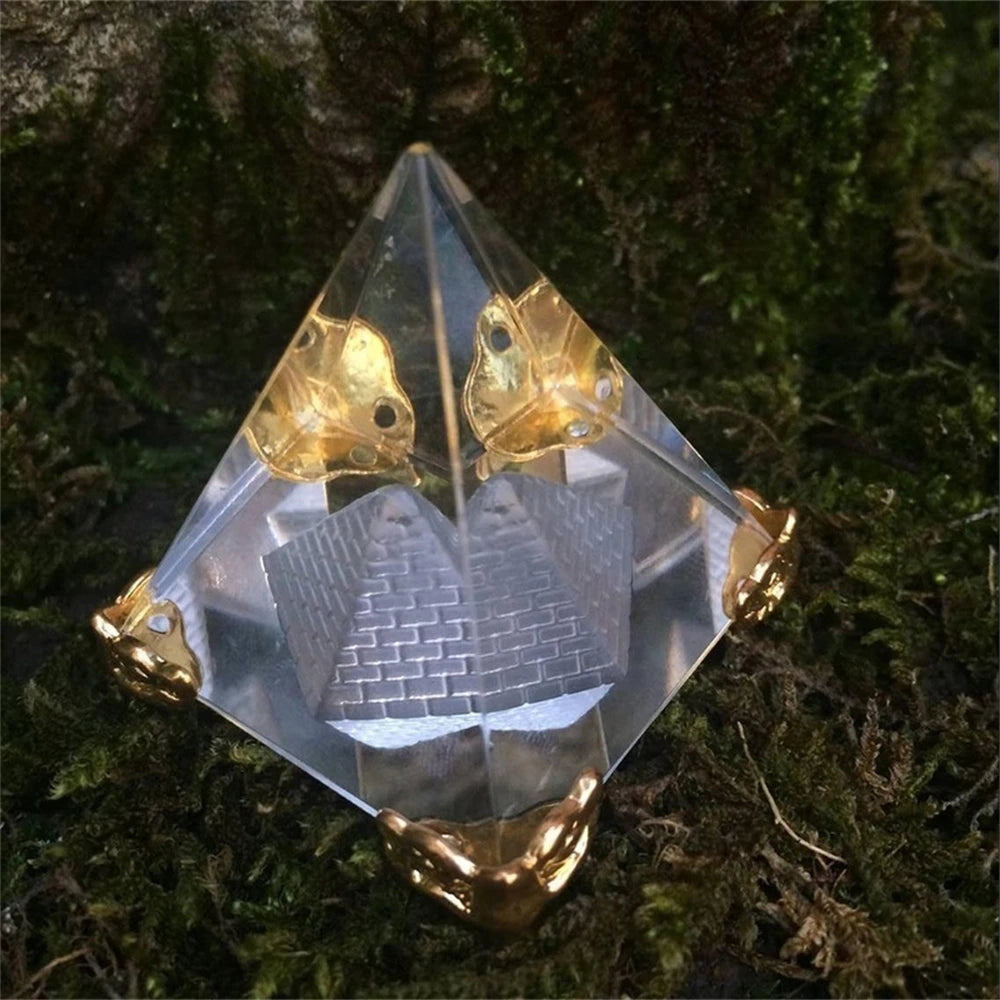 Crystal pyramid with engraved design on a mossy background