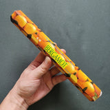 Hand holding a bergamot-flavored product package against a gray background