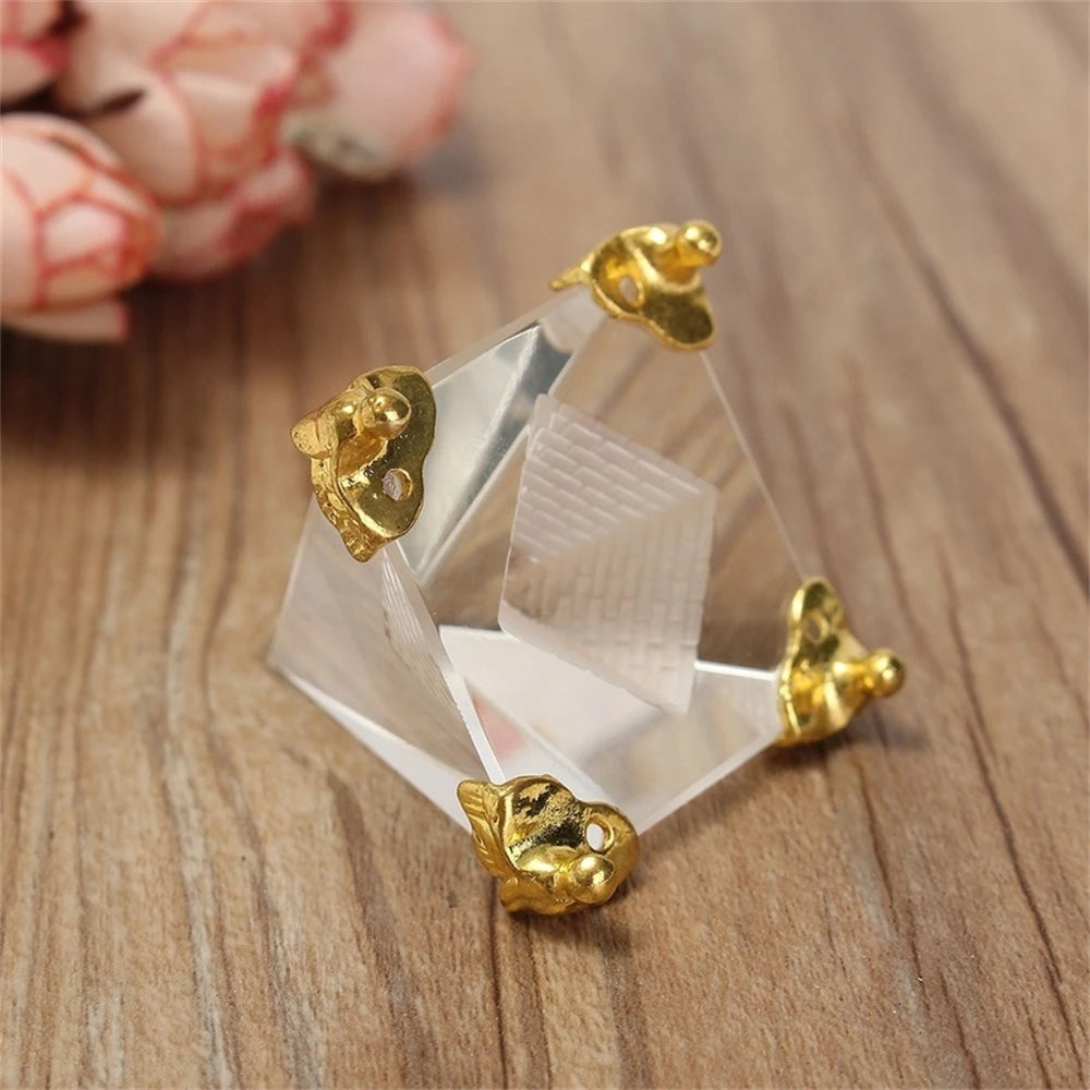 Gold and clear crystal earrings on a wooden surface