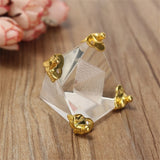 Gold and clear crystal earrings on a wooden surface