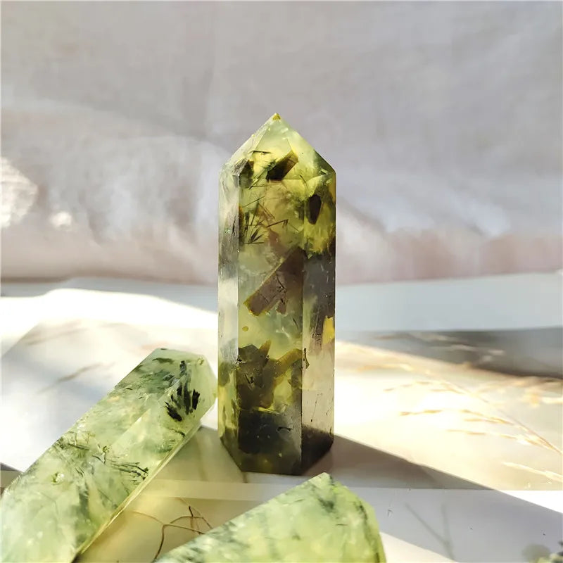 Green crystal tower on a white surface with a blurred background
