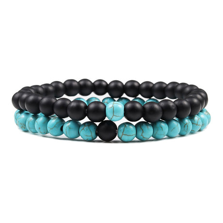 Stack of black and turquoise beaded bracelets on a white background
