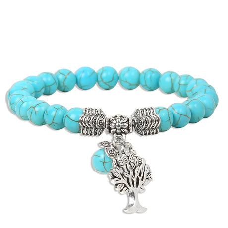 Turquoise beaded bracelet with silver charms on a white background