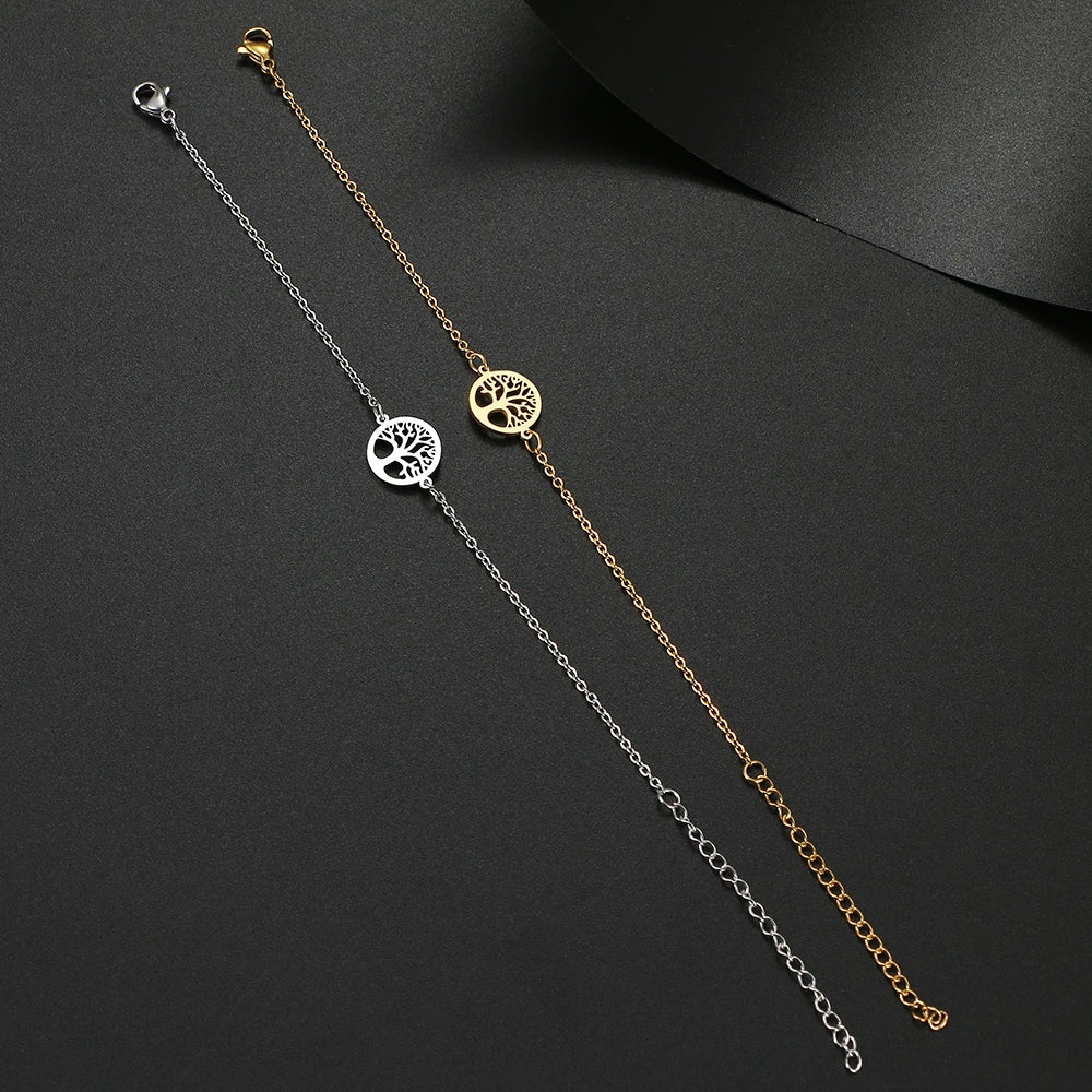Two gold and silver tree-of-life anklets on a dark surface