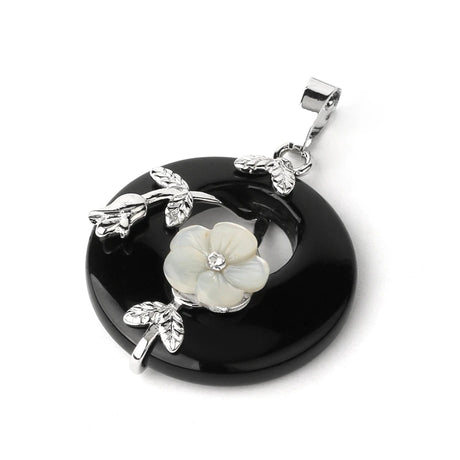 Black pendant with floral design and silver leaves on a white background