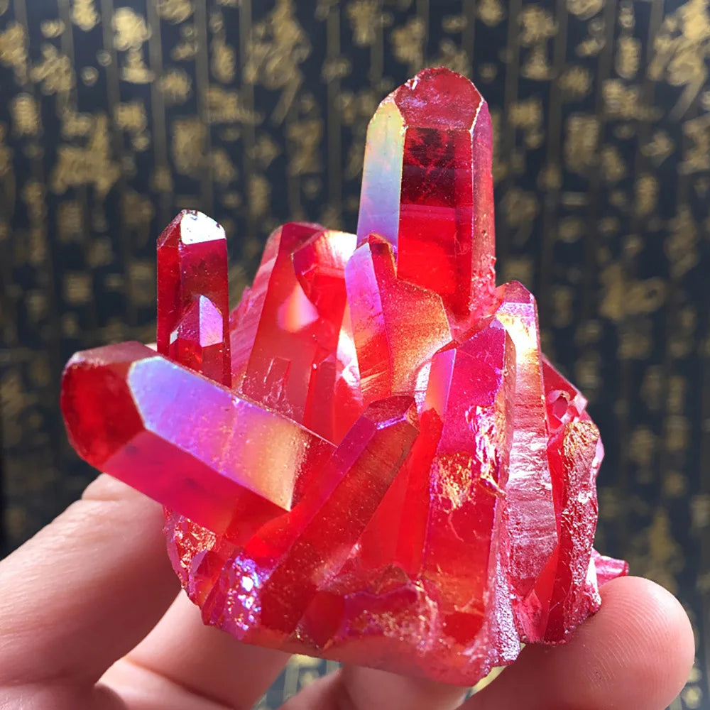 Red crystal formation held in a hand with a blurred patterned background