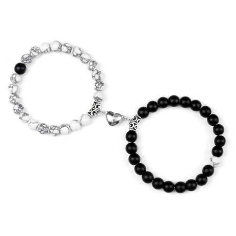 Two bracelets on a white background, one with black beads and silver accents, the other with white beads and silver accents.
