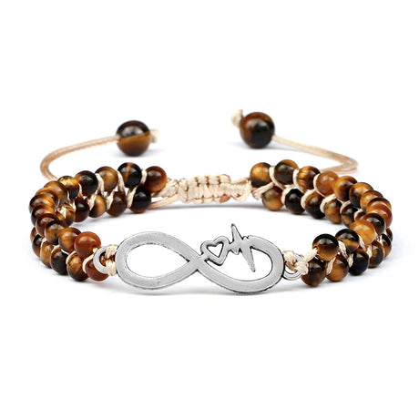 Bracelet with tiger eye beads and a silver infinity symbol charm on a white background