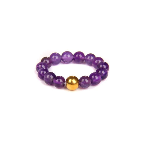 Purple beaded bracelet with a gold accent on a white background