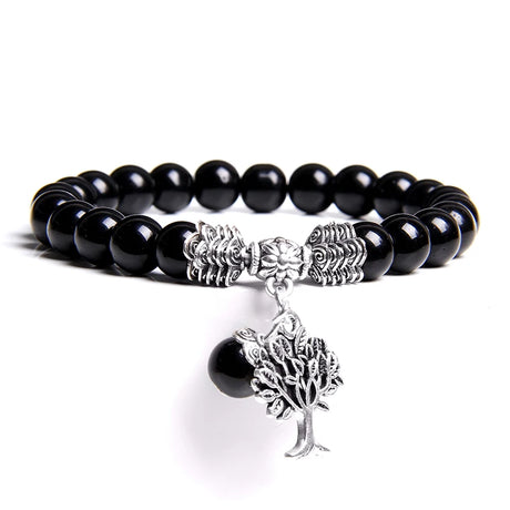 Black beaded bracelet with silver tree charm on a white background