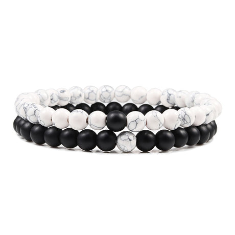 Set of three bracelets with white and black beads on a white background