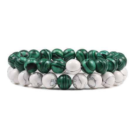 Set of green and white beaded bracelets on a white background