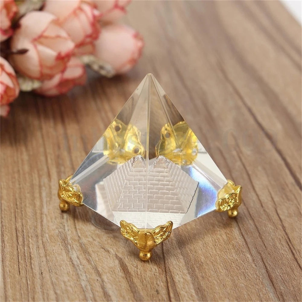 Crystal pyramid with gold accents on a wooden surface