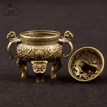 Decorative bronze incense burner with intricate designs on a dark background