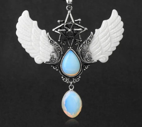 Necklace with angel wings and blue teardrop pendant on a dark background