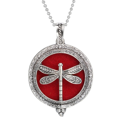 Silver pendant with dragonfly design on a red background, on a white background