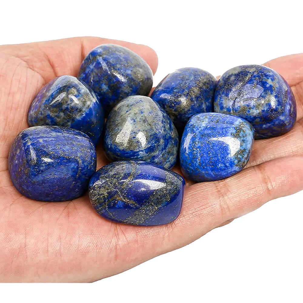 Hand holding blue stones against a white background