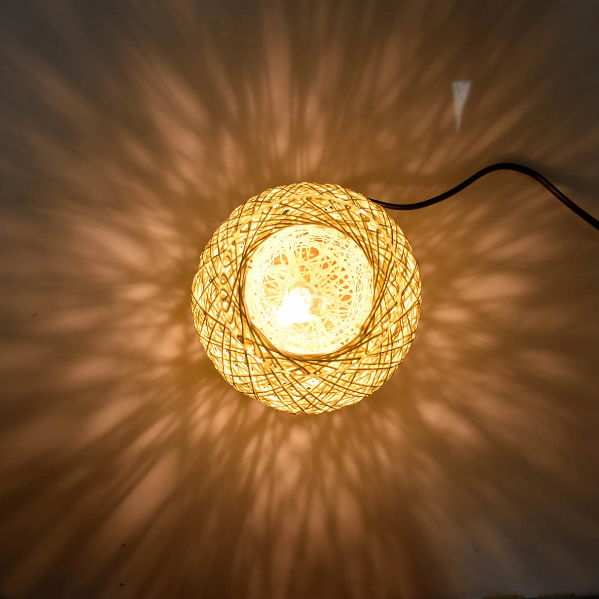 Woven string light casting a warm glow on a wall