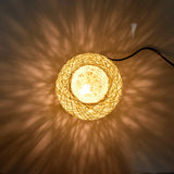 Woven string light casting a warm glow on a wall