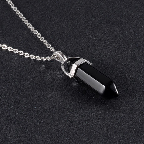 Black crystal pendant on a silver chain against a black background