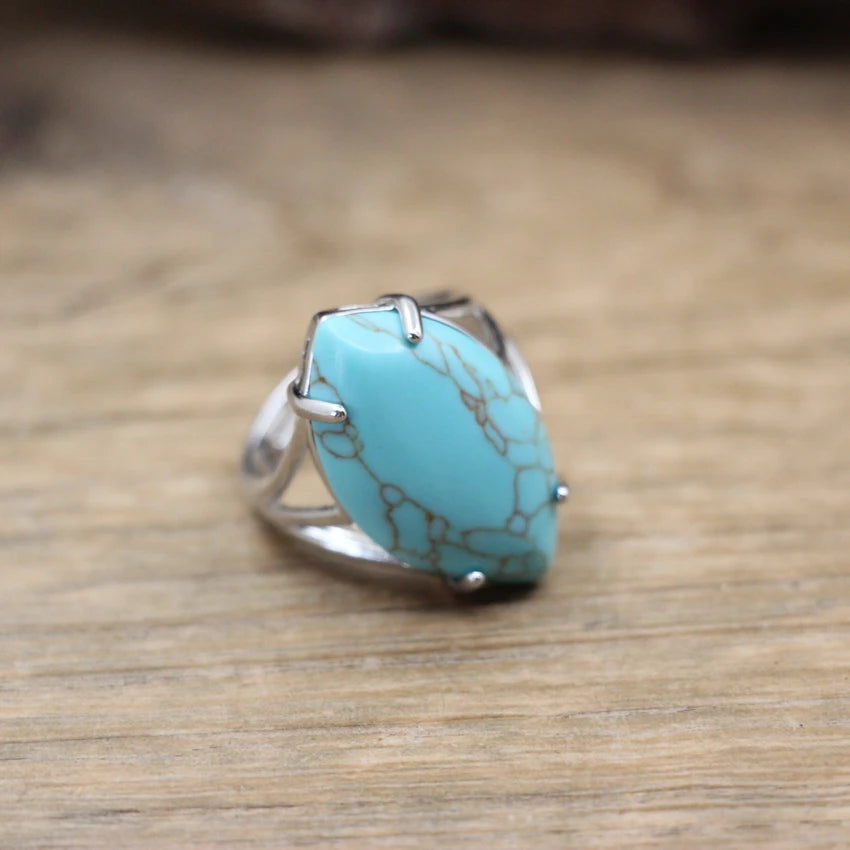 Turquoise ring with silver band on a wooden surface