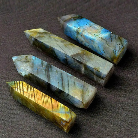Four crystal points with labradorite patterns on a brown surface