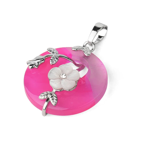 Pink pendant with silver floral design on a white background