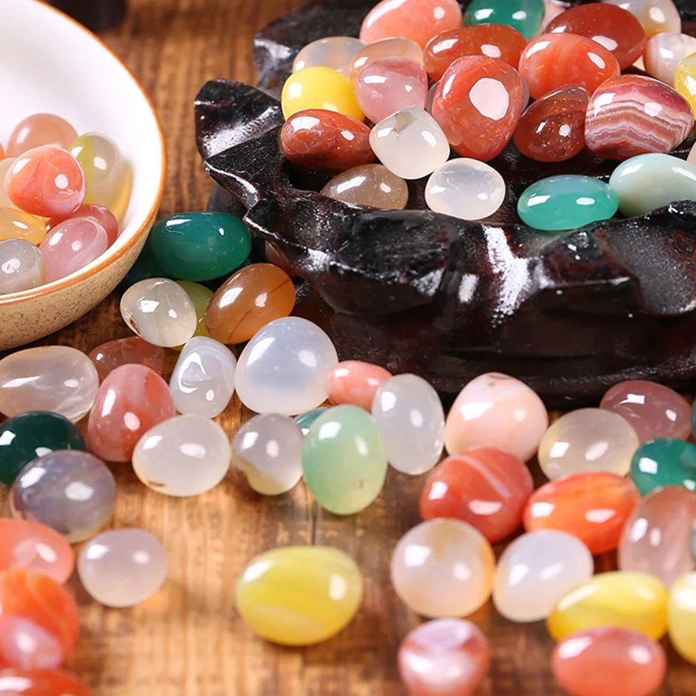 Colorful marbles in a black container on a wooden surface