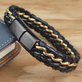 Black and gold braided leather bracelet on a wooden surface