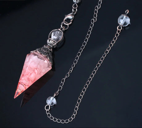 Crystal pendant necklace with pink gemstone on a dark background