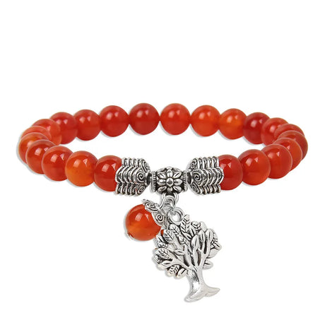 Bracelet with red beads and silver tree charm on a white background