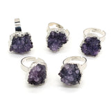 Set of purple crystal jewelry pieces with silver accents on a white background
