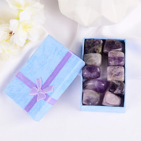 Box of gemstones with a decorative ribbon on a white background