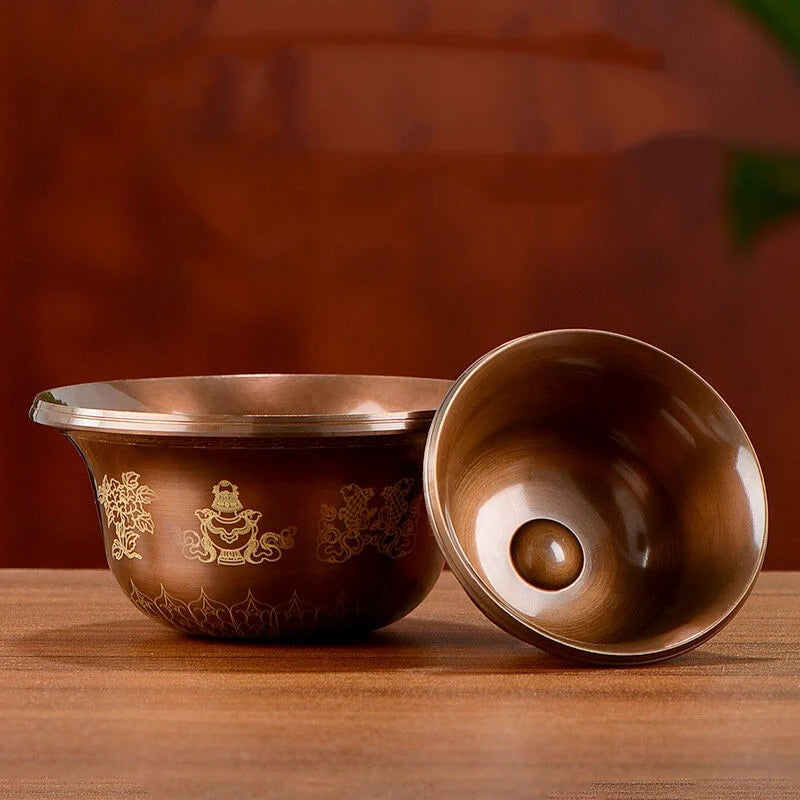 Two brown ceramic bowls with gold designs on a wooden surface.